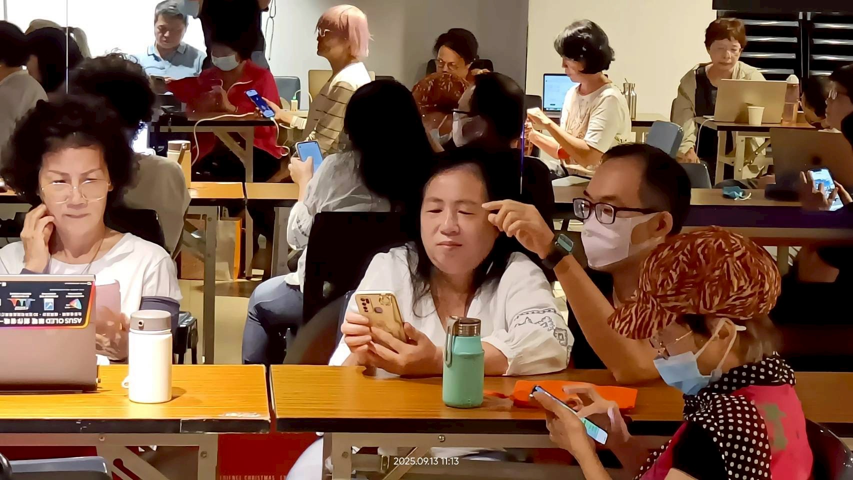 課程活動照片:多位學員在教室中使用電子設備