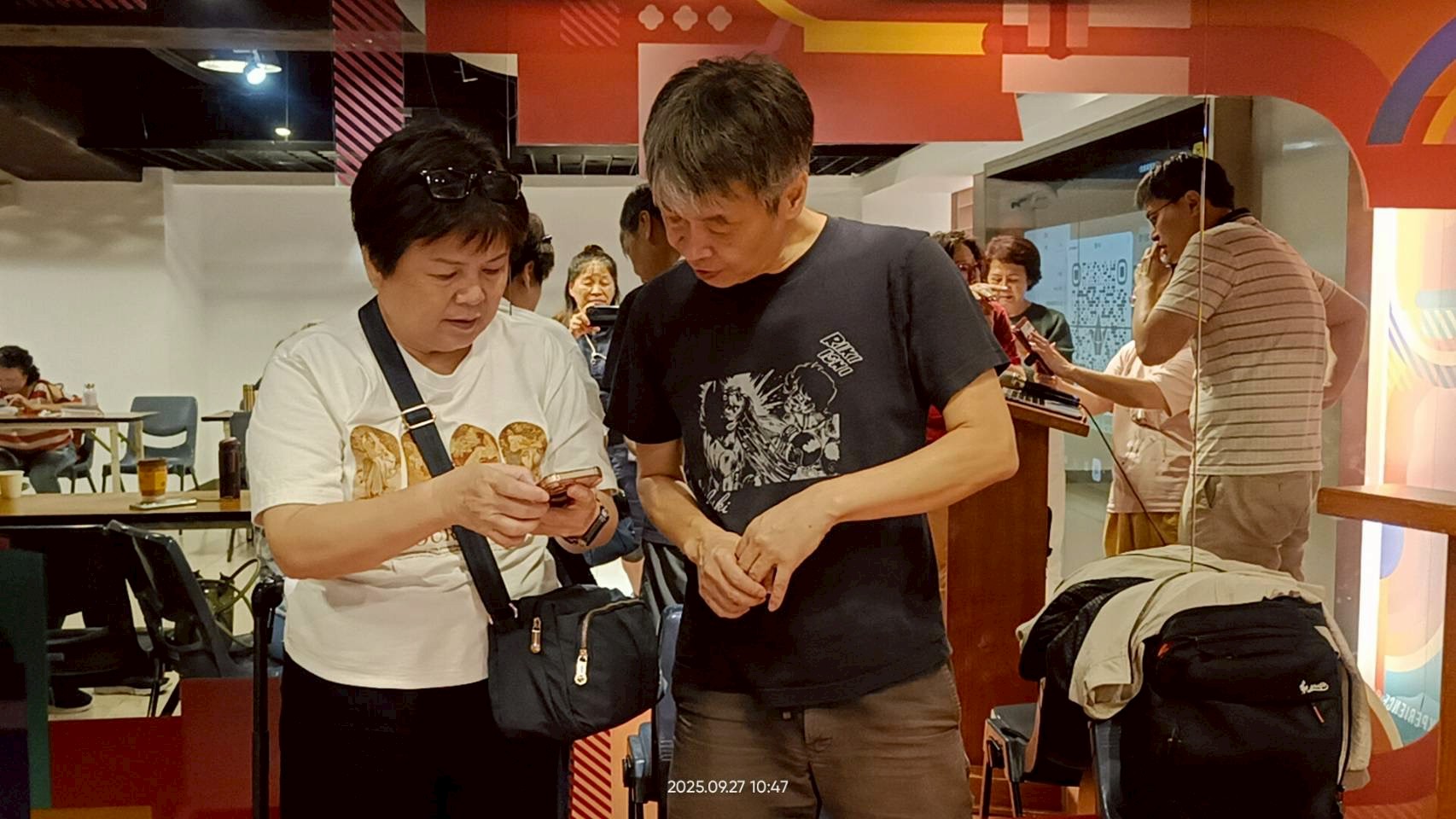 課程活動照片:兩位學員共同查看手機